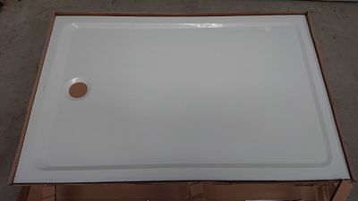 un gros plan d'un receveur de douche blanc posé sur une boîte en carton