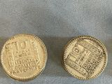 two gold coins sitting next to each other on a blue cloth