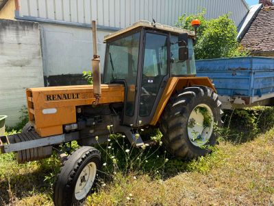 un tracteur garé dans l'herbe près d'un bâtiment