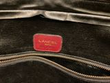 an image of a black purse with a red label on it