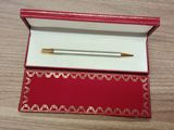 un stylo dans une boîte rouge posée sur une table en bois