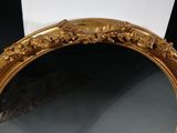 an ornate gold framed mirror with flowers and leaves on it