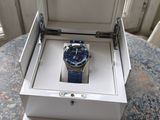 a watch in a box on a table by a window