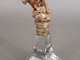 a statue of an angel on top of a glass bottle