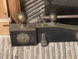 two old fashioned wooden boxes sitting next to a fire place