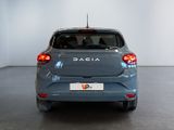 the back end of a blue car in a room with a white wall