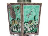 un vase vert orné d'un motif représentant un oiseau et des fleurs