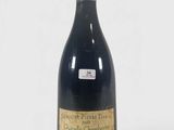 une bouteille de vin posée sur une table blanche