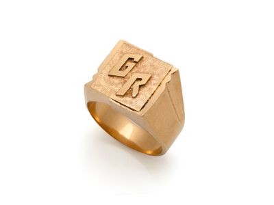 un gros plan d'une bague en or sur laquelle figure la lettre « k »