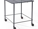 a black metal table with wheels on a white background