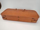 a brown suitcase sitting on top of a table next to a clock