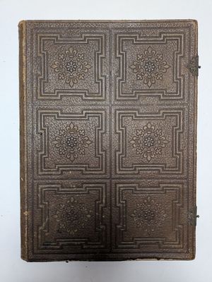 un vieux livre posé sur une table à côté d'un mur blanc