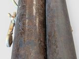 two wooden pipes with metal handles on a white surface