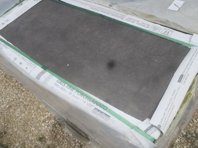 une boîte posée par terre, recouverte d'un drap