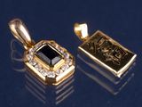 deux pendentifs en or sertis d'une pierre noire et de diamants sur un fond bleu