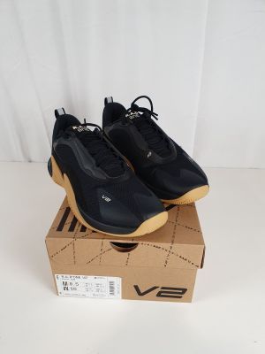 a pair of black sneakers sitting on top of a cardboard box
