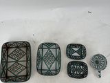 four pieces of green and white pottery sitting on top of a white surface