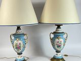 pair of blue and white vase lamps on a table with a picture frame