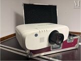 un projecteur blanc posé dans un étui sur une table