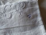 two napkins with monograms on them sitting on a table