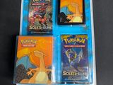 three pokemon trading cards in a plastic case on a table