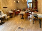 tables and chairs in a restaurant with a fireplace in the background