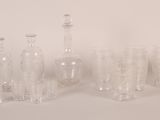 bottles and glasses are lined up in a row on a white surface