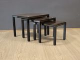 three black nesting tables sitting on top of a hard wood floor