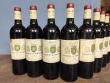 six bottles of wine are lined up on a wooden table