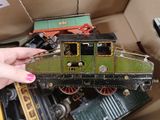 une personne tenant un petit train miniature dans une boîte