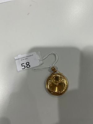 un gros plan d'une pièce d'or sur laquelle est accrochée une étiquette