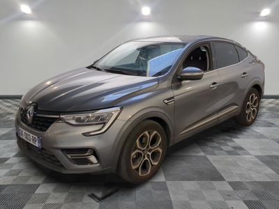 une voiture grise garée dans une pièce au sol en damier