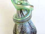 a glass vase with a bird on top of it
