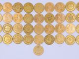 a close up of a pile of gold coins on a white surface