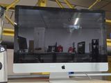 un écran d'ordinateur posé sur un bureau, à côté d'un mixeur