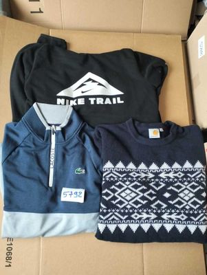 two men ' s sweaters in a box with a mountain logo on them