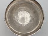 a silver bowl sitting on a table with a white background