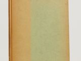 a brown book with a green cover sitting on top of a white table