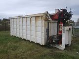 a dumpster that is sitting in the middle of a field