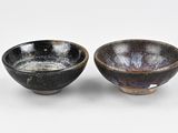 pair of black and white bowls on a white surface