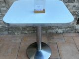 a white table with a card on it on a brick floor