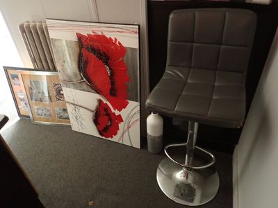a chair that is next to a painting on the wall