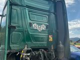 a green truck that is parked on the side of the road