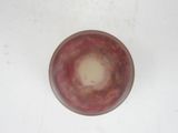 a red bowl sitting on a white surface with a white background