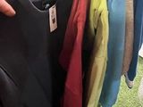 a person holding a rack of clothes in a store