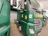 many green trucks parked next to each other in a parking lot