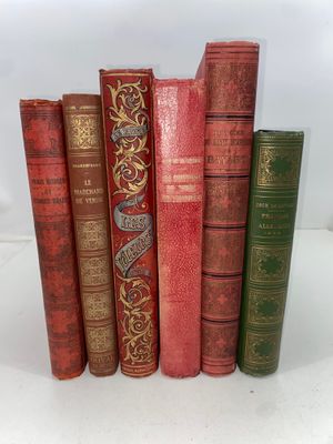 cinq vieux livres sont alignés sur une surface blanche
