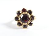 une image représentant une bague en or sertie de grenats