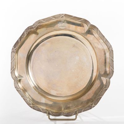 a silver plate on a stand on a white surface