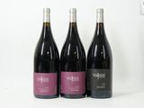 trois bouteilles de vin sont alignées sur une surface blanche